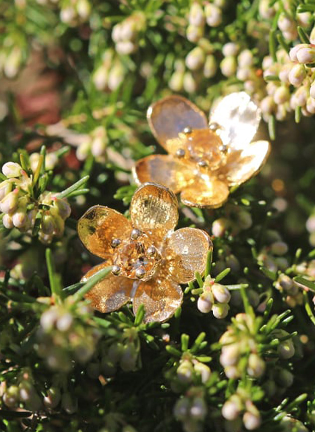 Citrine Buttercup Earrings on a bed of flowers by Alex Monroe Jewellery