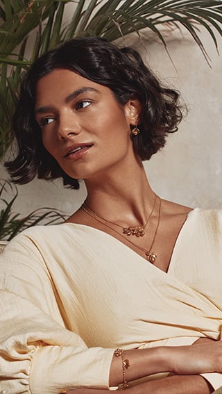 Model wearing yellow top, wears Alex Monroe's lemon and Orange Blossom Branch Necklace with Hanging Oranges