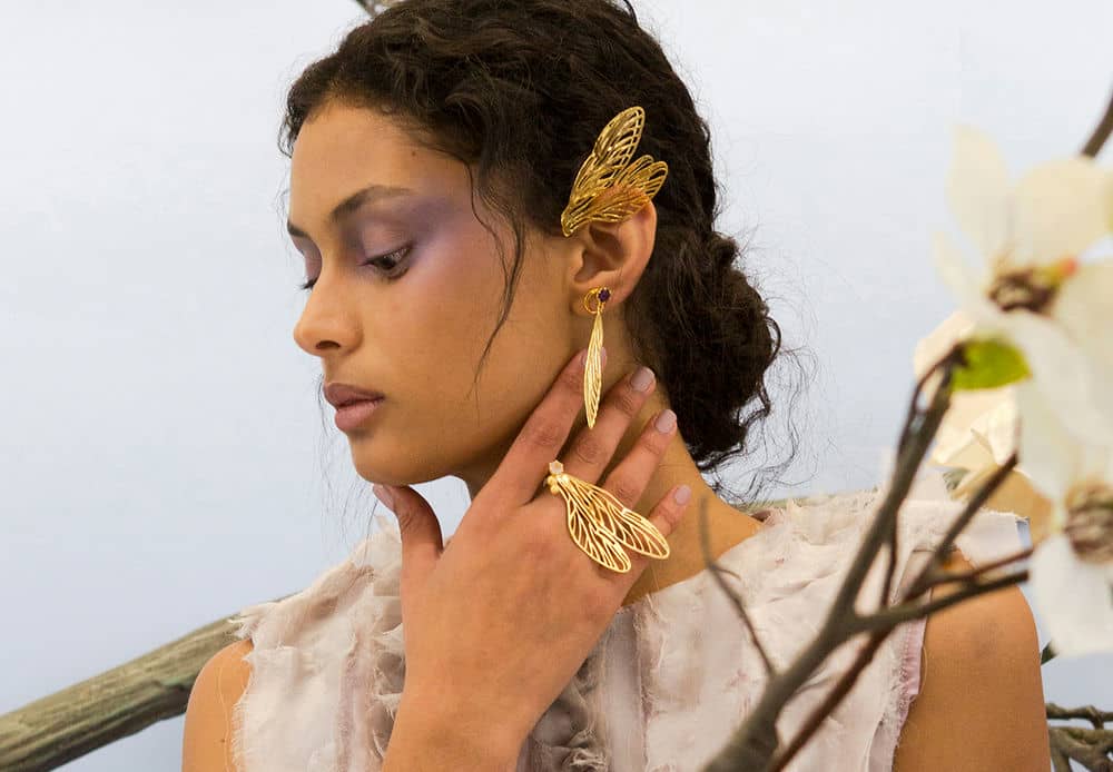 Large statement Dragonfly Wing ear cuff, hanging earring and double ring, modelled by a woman with ethereal pink eyeshadow.